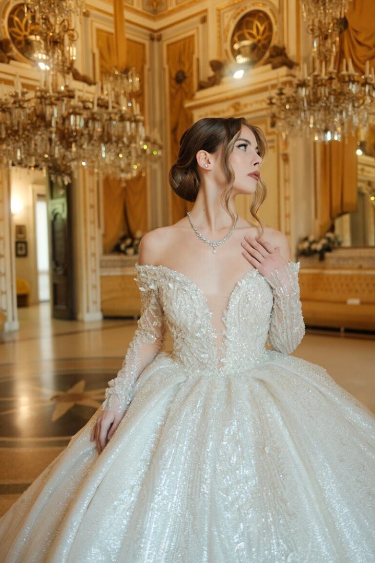 A beautiful bride elegantly posed in an ornate ballroom, wearing a stunning white gown.