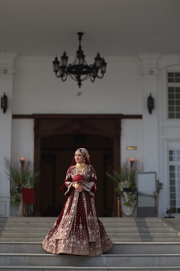 Bride in ornate red dress standing on steps